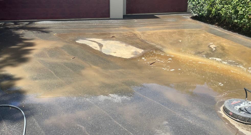 Driveway with heavy brown staining before pressure cleaning